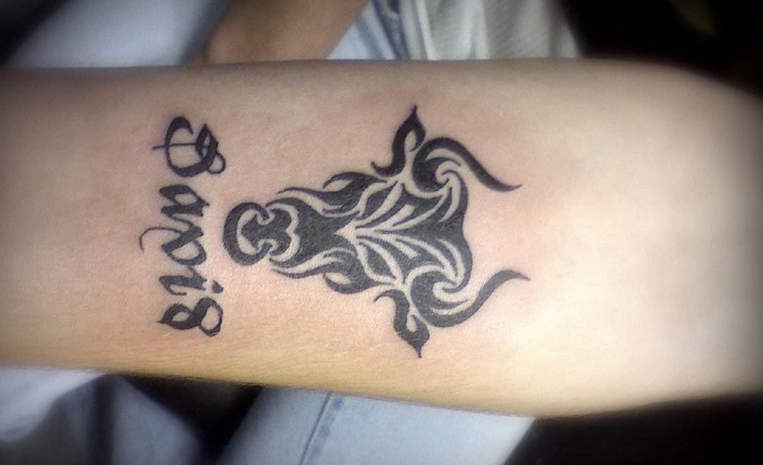 Tribal Stier Sternzeichen Tattoo mit Namen am Unterarm